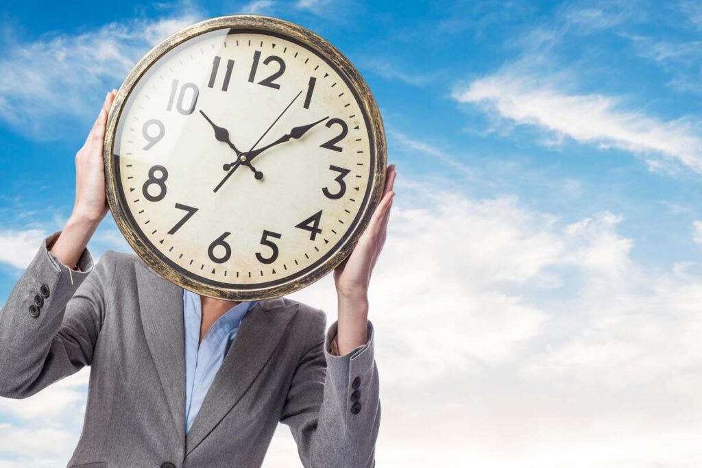 Time Management, woman holding a clock infront of ther face